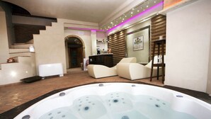 Ein Wellnessbereich mit Whirlpool, Rezeption und einer Sitzecke mit Sesseln.