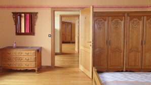 Une chambre à coucher avec des meubles en bois, une commode, une armoire et un lit.