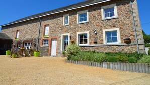 A stone building with a gravel driveway and a wooden fence. - Cottage in Former Farmhouse in Tillet (Sainte-Ode)