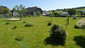 A rural setting with a stone house, a fenced area, and a grassy field. - Cottage in Former Farmhouse in Tillet (Sainte-Ode)