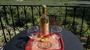A table with a bottle of wine and two glasses on a tray, set against a scenic mountain backdrop. - Villa in Paleokastrites with Swimming Pool near Beaches (Corfu)
