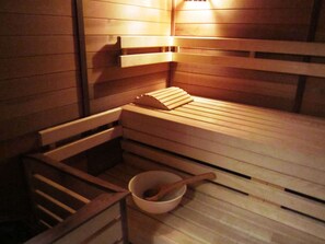 En sauna med træbænke og en træskål med en træske.