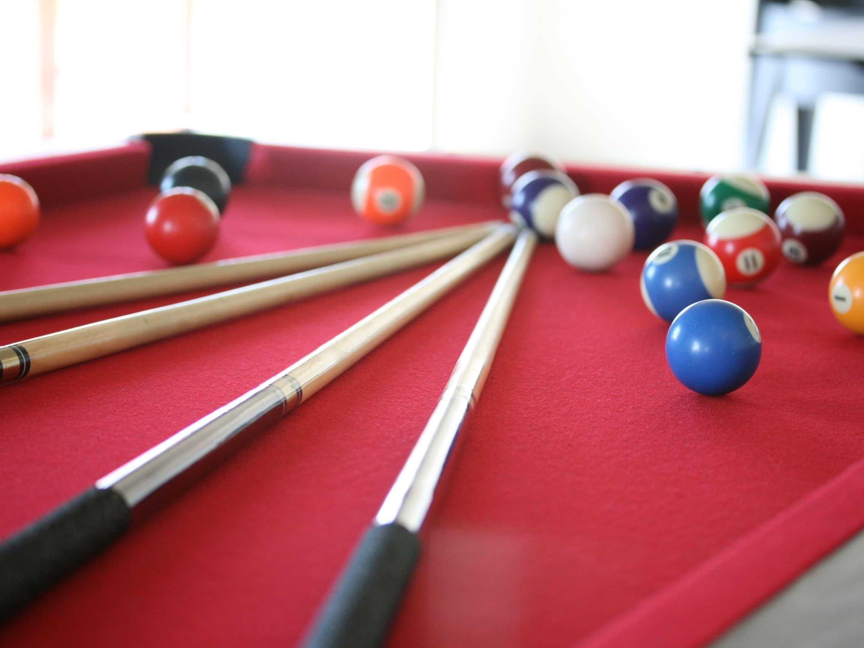 A pool table with billiard balls and cues.
