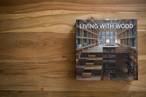 A book titled "LIVING WITH WOOD" on a wooden surface. - Stylish and Spacious Apartment in Thiseio (Athens)