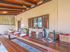 A wooden dining table set with plates, glasses, and a basket of fruit. - Heritage House in Orihi With an Elegant Garden (Barban)