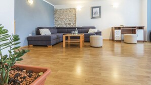 Ein modernes Wohnzimmer mit Sofa, Hocker, Couchtisch und einem Schreibtisch mit Schubladen.