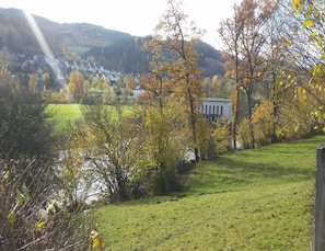 A rural landscape with a river, autumn foliage, and a distant village. - Ferienwohnung in Wehrstapel (Meschede)