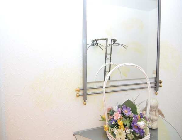 A bathroom with a mirror, towel rack, and a decorative angel statue. - Ferienwohnung in Wehrstapel (Meschede)