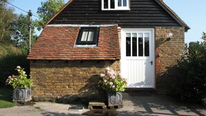 A small, two-story house with a steeply pitched roof, a white door, and a small window. - Snug, traditional and romantic perfect for that weekend getaway. (Icklesham)