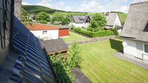 Ein Wohngebiet mit Häusern, einem Rasen und einer hügeligen Landschaft im Hintergrund.