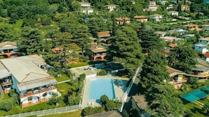 An aerial view of a residential area with houses, a swimming pool, and lush greenery. - Holiday Home in Manerba del Garda Near Lake (Manerba del Garda)