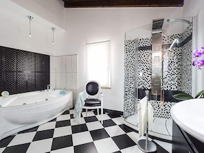 A modern bathroom with a checkered floor, a large bathtub, a shower with mosaic tiles, and a vanity with a mirror. - Exclusive Luxury Villa in Agrigento with Private Pool, Hot Tub, BBQ (Agrigento)