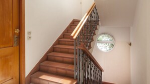 A staircase with wooden steps and metal railings, leading to a landing with a window. - Belvilla by OYO Catalani Bilo (Riccione)