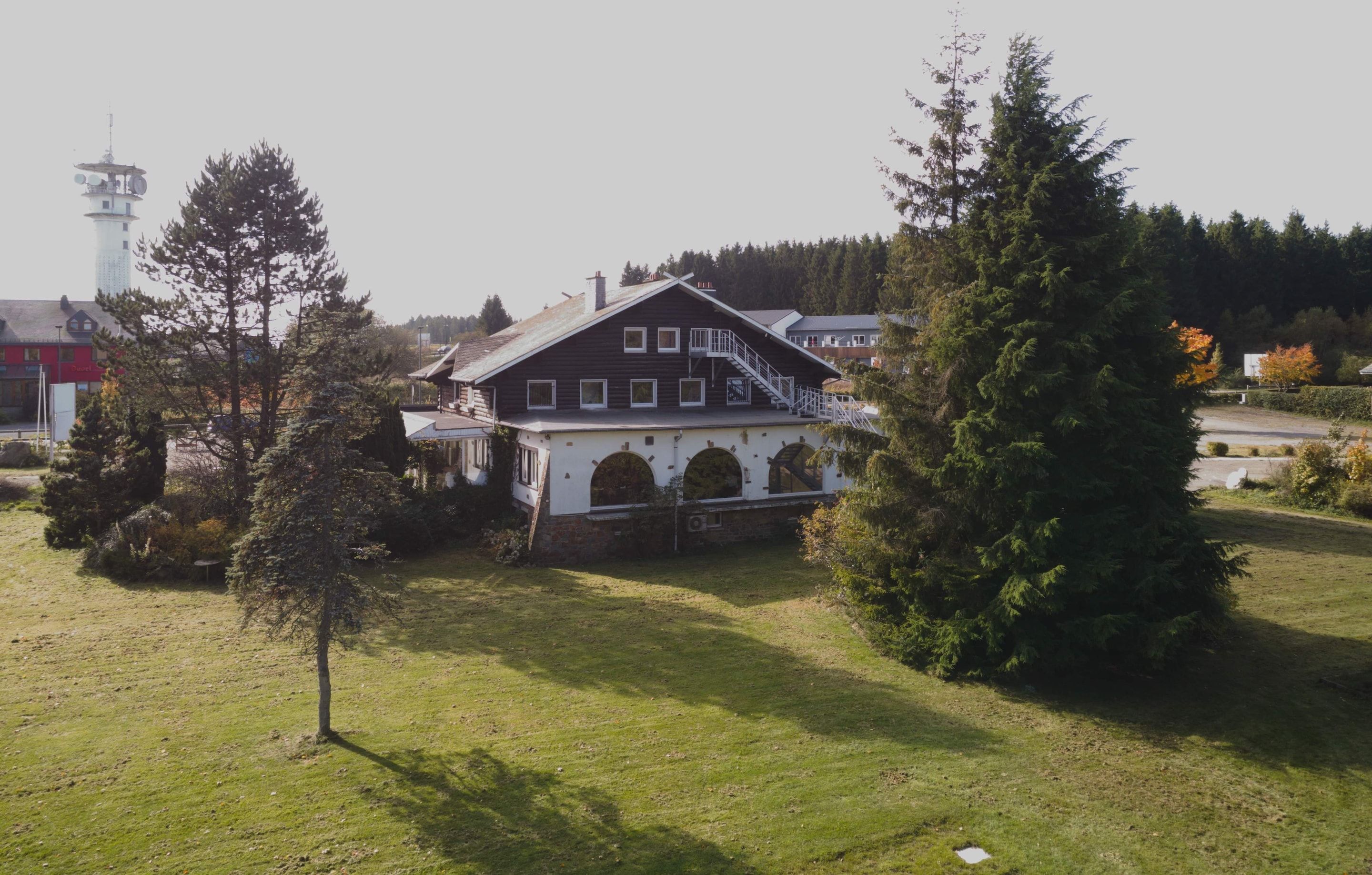 Ein großes, zweistöckiges Gebäude mit einer markanten Treppe und Rundbogenfenstern.