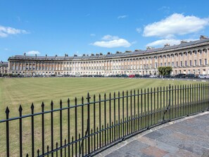 A large, historic building with a long facade, a well-maintained lawn in front, and a black iron fence. - The Coach House - 15661 (East Tytherton, Chippenham)