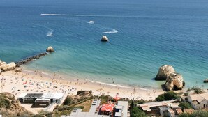 A coastal beach with clear blue waters, rocky formations, and a sandy shore. - Flat Rose Garden Sea View (Portimão)