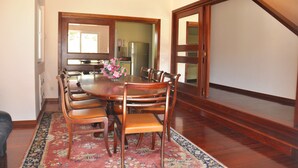 A dining area with a wooden table, six chairs, and a floral centerpiece. - Villa in Vilamoura With Private Pool & BBQ (Loulé)