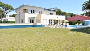 A two-story house with a swimming pool, a covered patio, and a well-maintained lawn. - Villa in Vilamoura With Private Pool & BBQ (Loulé)