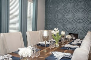 A dining table set for a formal meal with chairs, a vase of white flowers, and wine glasses. - 2606YA Luxurious En-Suite Single Home Pool (Kissimmee)