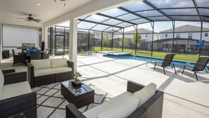 Une vaste terrasse dotée de mobilier d’extérieur, d’un jacuzzi et offrant une vue sur un quartier résidentiel.
