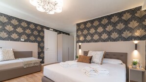 A modern bedroom with a large bed, a sofa, and a nightstand.