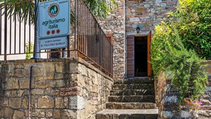 Uma escadaria de pedra leva a um edifício com placas que indicam 'Agriturismo Italia' e 'Il Vecchio Borgo'.