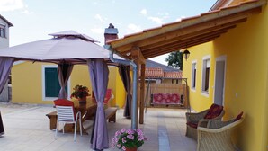 A covered outdoor seating area with a table and chairs, a wicker chair, and a potted plant. - Detached House at Country Side, Fenced Private Garden Ideal for 2 Fam, Wifi (Vodnjan)