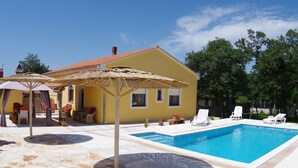 A yellow house with a swimming pool, outdoor furniture, and umbrellas. - Detached House at Country Side, Fenced Private Garden Ideal for 2 Fam, Wifi (Vodnjan)
