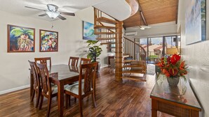 Ein geräumiger Essbereich mit Holztisch und -stühlen, eine Treppe mit Holzgeländern und Blick ins Freie.