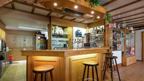 A bar area with stools, a counter, and shelves with glassware and bottles. - Group Cottage in Lierneux (Lierneux)