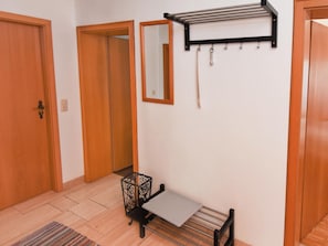 Effortlessly organized space with a foldable table, wall-mounted drying rack, and mirror.
