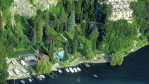Eine Luftaufnahme einer Küstenregion mit einem Yachthafen, einem Schwimmbad und einem Wohngebäude mit Balkonen.