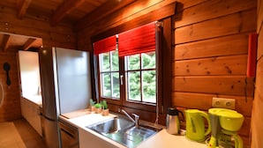 A compact kitchen with a stainless steel sink, a refrigerator, and a coffee maker. - Chalet in Ardennes With Sauna & Garden (Waimes)