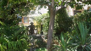 A lush garden with a variety of plants and a tree in the center. - Comfortable Apartment Near the sea (Medulin)