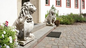 A building entrance with two stone lion statues and a paved pathway.