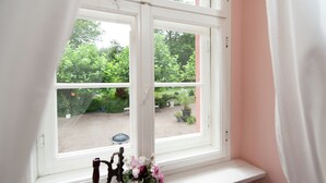 A window with a view of a garden and outdoor seating area.