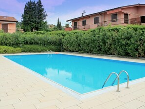A rectangular swimming pool with clear blue water, surrounded by a tiled deck. - Great and Colourful Apartment Near Bardolino (Bardolino)