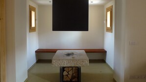 A room with a central stone table, wooden benches, and a black ceiling panel. - Modern Accommodation, Just Renovated, Private Garden, Wifi, Near Treviso (Volpago del Montello)