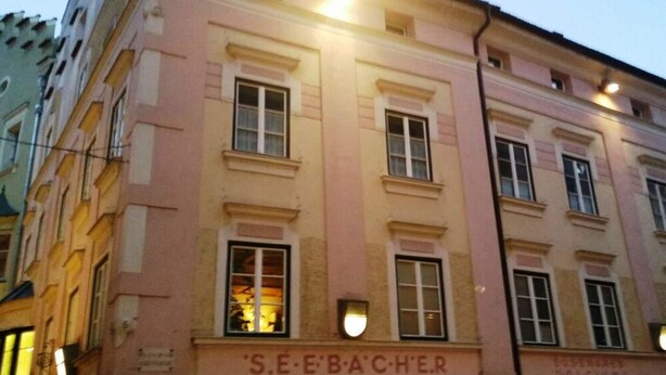 Um edifício com a placa 'S.E.E.BACCHER', indicando um estabelecimento comercial.