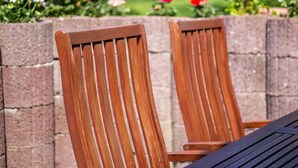 Two wooden chairs with slatted backs, positioned at a table with a dark surface. - Schoene Ferienwohnung in Damshagen an der Ostsee (Damshagen)