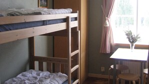 A bunk bed room with a desk and chair, a window with curtains, and a framed picture on the wall. - A Grand Getaway for Family and Friends (Sysslebäck)