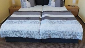 A double bed with a black headboard, two nightstands, and a patterned bedspread. - Apartment in Kropelin With Terrace (Kroepelin)