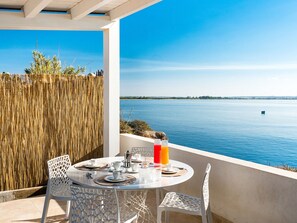 Ein Tisch für zwei mit Blick auf ein ruhiges Meer und eine entfernte Küste.