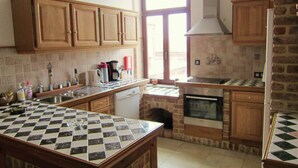 Une cuisine avec des meubles en bois, un plan de travail à carreaux, un lave-vaisselle, une cuisinière et une fenêtre donnant sur un beau paysage.