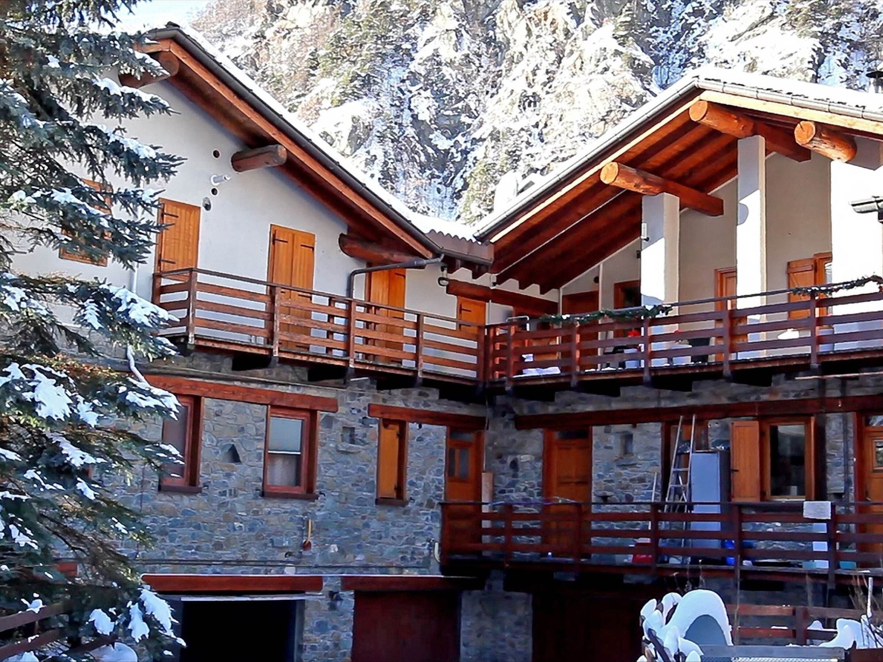 A multi-story building with stone walls and wooden balconies.