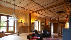 A rustic interior with a wooden bar, leather seating, and a kitchen area.