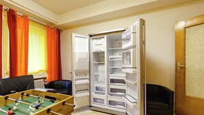 A room with a foosball table, a refrigerator, and a door. - Dog-friendly Holiday Home in Hesse With Garden (Bad Zwesten)