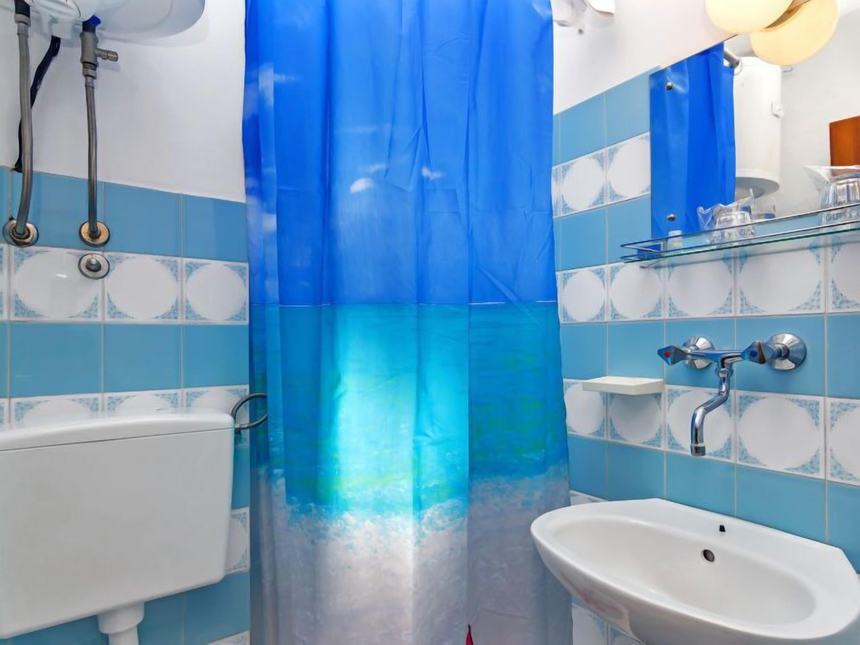 Une salle de bain avec une baignoire, un lavabo et un rideau de douche.