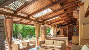Una zona relax all'aperto accogliente, con mobili in vimini e un pilastro in pietra.
