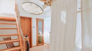 Una scala in legno conduce a una stanza con una porta in legno e una porta in vetro.